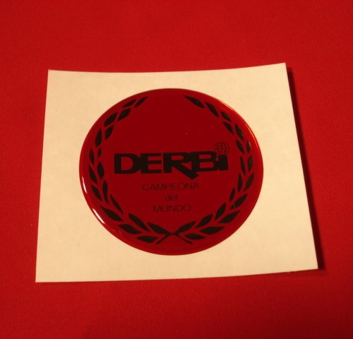 ADHESIVO DERBI ROJO EN RESINA DE 49MM DIAMETRO